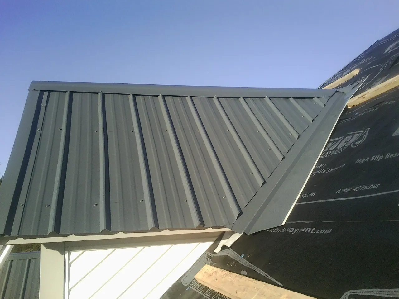 Gray metal roof panels going on over a garage gable in Blacksburg